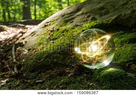 Magic crystal ball atom on forest floor for summer fantasy imagery