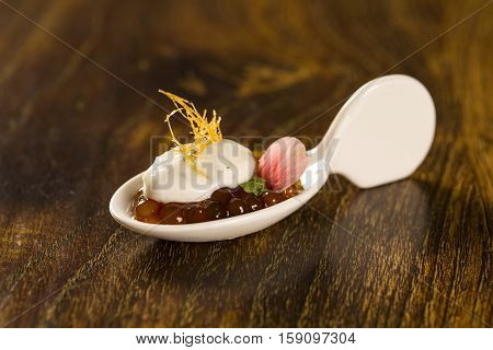 Natural Flavored Mint Yogurt, Pepper Sago Finished With Caramel In A Spoon. Taste Gastronomy Finger