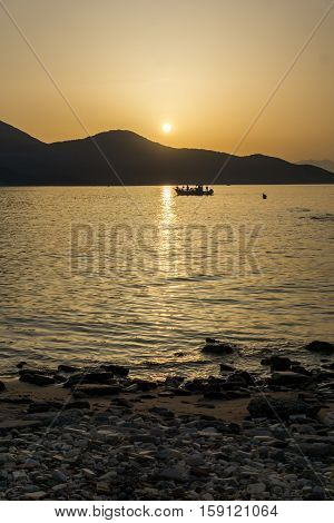 Sunset seascape with old boat in the sea of Thassos town, East Macedonia and Thrace, Greece