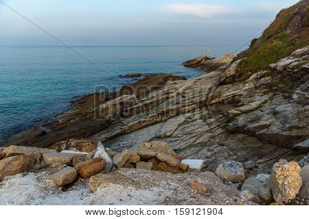 Amazing Sunset view with rocks in the sea of Thassos town, East Macedonia and Thrace, Greece