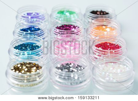 glitter for nail decoration on the white bacground