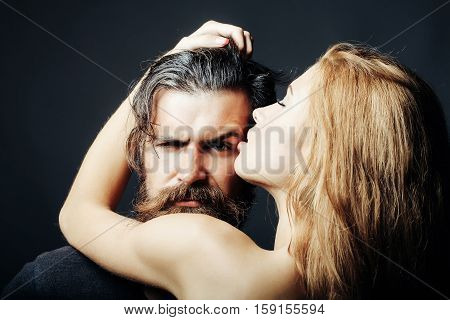 bearded handsome man and female slim flexible body of young pretty sexy woman or girl has long blonde hair embracing