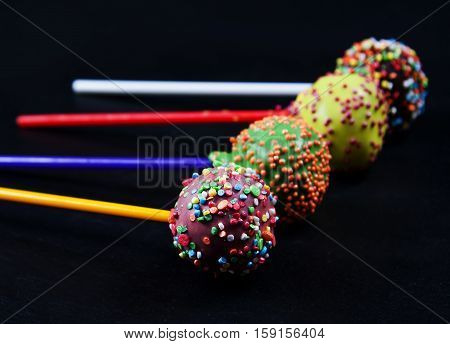 cake pops in chocolate glaze over black