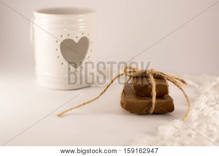 candle holder with heart lace and chocolateh on a white backgraund
