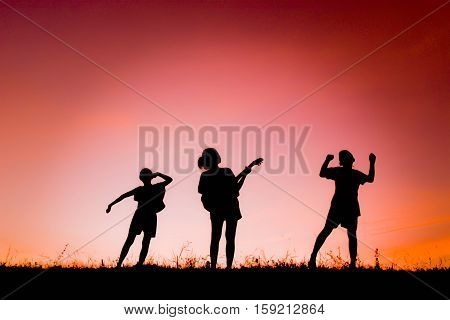 Silhouette of people playing guitar at the sky sunset happy time in holiday vintage tone