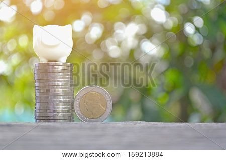 piggy bank with a coin on old wood bokeh background.concept save money