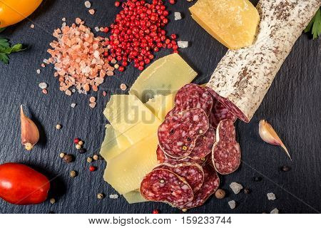 Top View Of Tasty Fresh Yellow Thin Slice Parm Cheese, Salami, Dry Pepper, Himalayan Salt, Tomatoes,