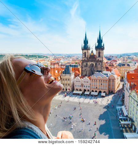 Kostel Panny Marie pred Tynem. Church of the Virgin Mary. A young woman stands on top of the clock tower and looks at the Old Town Square in Prague