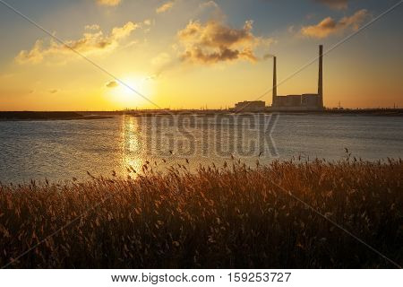 Beautifull landscape with thermal power plant lake and sunset sky.