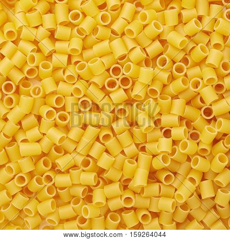 Pile of dry ditalini yellow pasta as abstract background