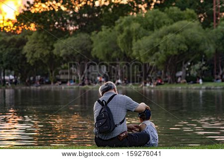 Grandpa And Nephew Relaxing In Chatuchak Park