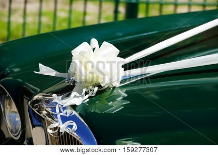 London, UK, May 23, 2010 : Wedding car with its white silk band and bow celebrating a white wedding outside a church waiting for the bride and groom