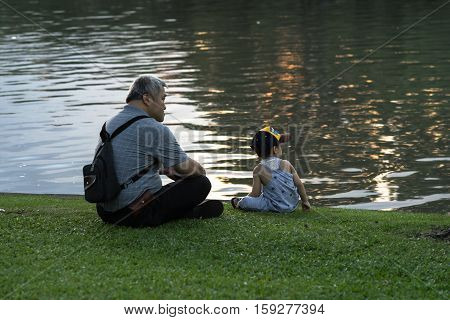 CHATUCHAK PARK, BANGKOK, THAILAND - NOVEMBER 27 : Grandpa and grandson relaxing in Chatuchak Park on the November 27, 2016 in Chatuchak Park, Bangkok.
