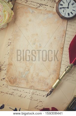 old blank paper on pile of old letters with feather pen, retro toned