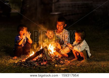 Disadvantaged children are sitting by a warm fire.