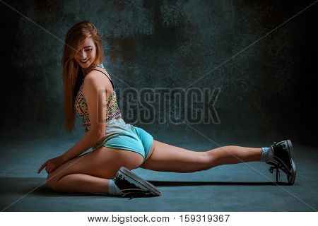 Attractive girl dancing twerk iat the blue studio background
