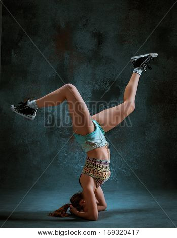 Attractive girl dancing twerk iat the blue studio background