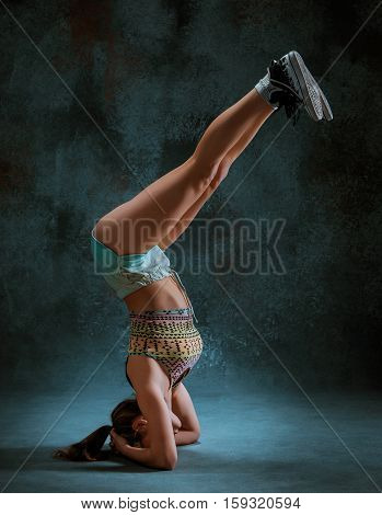 Attractive girl dancing twerk iat the blue studio background