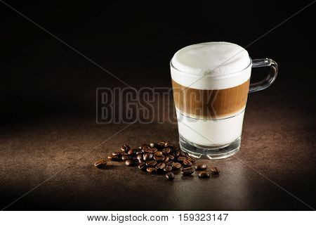 Glass of hot Latte macchiato coffee close up