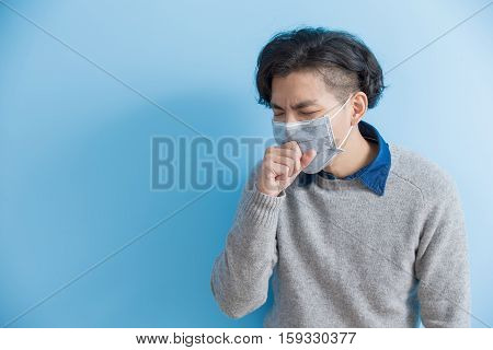 man is coughing isolated on blue background asian