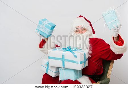 Santa Claus holding pile of gift boxes Closeup Portrait.