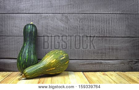 Green raw pumpkin on a old wooden background. Crop. Organic products. Autumn. Country furnishings. Season.