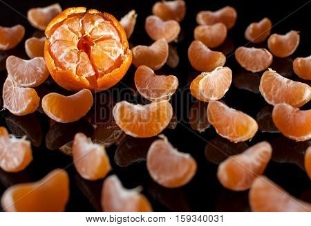 Group Of Mandarin Slices With Reflection On Black Background