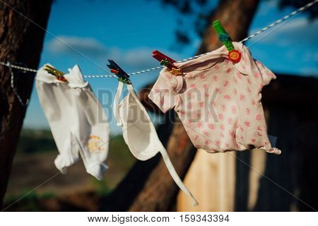 baby clothes drying on a rope in the woods