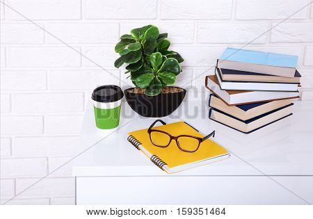 Workplace with cup of coffee and education stuff in the room. Copy space