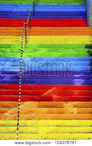 The concrete stairs on the street are painted in rainbow colors. Background