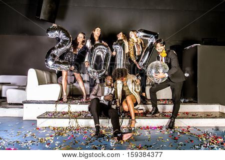 Multi-ethnic group of friends celebrating the end of the year in a nightclub - Sylvester party clubbers having party on new year's eve