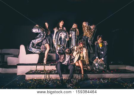 Multi-ethnic group of friends celebrating the end of the year in a nightclub - Sylvester party clubbers having party on new year's eve
