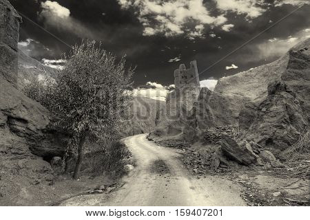 Ruins and Basgo Monastery surrounded with stones and rocks Leh Ladakh Jammu and Kashmir India. Black and white image.