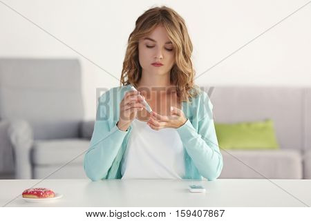 Woman using lancelet on finger