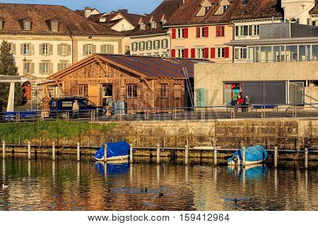 Rapperswil, Switzerland - 30 November, 2016: boats at the emabnkment of Lake Zurich, people and buildings on Fischmarktplatz square at sunset. Rapperswil is a part of the municipality of Rapperswil-Jona in the Swiss Canton of St. Gallen.