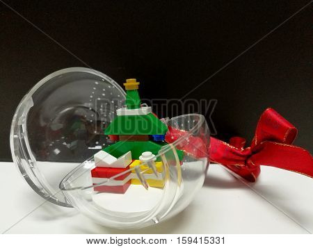 Merry Christmas and Happy New Year, closed up colorful Xmas tree and tiny gift box toy decoration in the clear ball