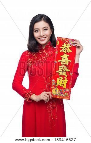 Portrait of a beautiful Asian woman on traditional festival costume Ao Dai showing New Year scrolls Tet holiday. Lunar New Year.