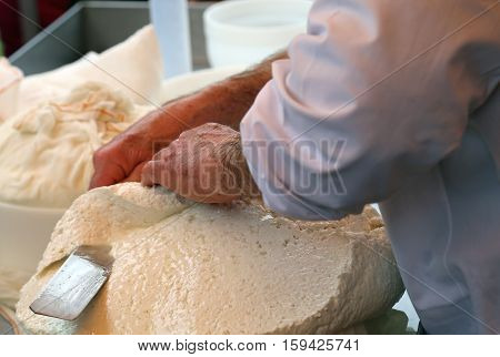 Man Cuts The Cheese Freshly Prepared In The Dairy