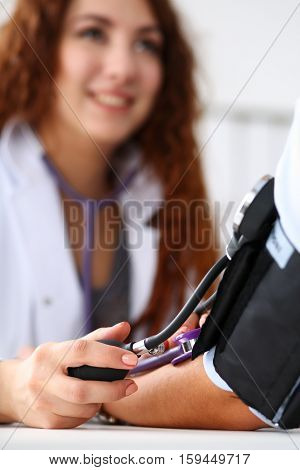 Female medicine doctor measuring blood pressure to patient. Patient communicates with physician doctor having medical examination. Medical concept. Hand of doctor and patient while pressure measuring