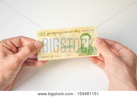Man Holding Twenty Bhutanese Ngultrum Banknote In His Hands