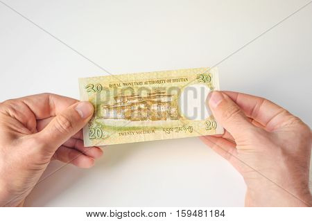 Man Holding Twenty Bhutanese Ngultrum Banknote In His Hands