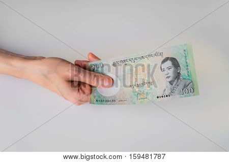 Woman Holding Hundred Bhutanese Ngultrum Banknote In Her Hand