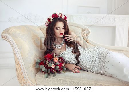 Beautiful Brunette Bride Lying On Classic Elegant Sofa, Baroque Style Ornaments. Makeup. Long Wavy H