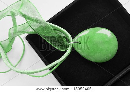 Green nephrite necklace in black jewel box closeup