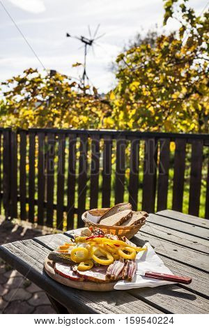 Brettljause traditional wooden plate with cold cuts only with self-made food on terrace in vineyard on western Styria vine route