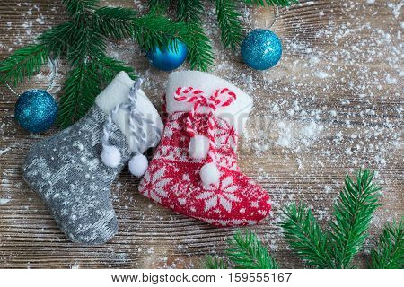 Two Christmas Stockings On Snowbound Wooden Background, Blue Balsl Ornaments