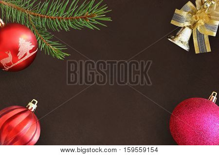 Christmas fir branch red wavy and pink ball bell on a dark background