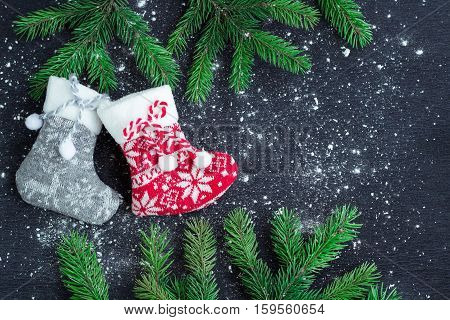 Christmas Stockings Pair On Snowbound Black Background With Fir Branches