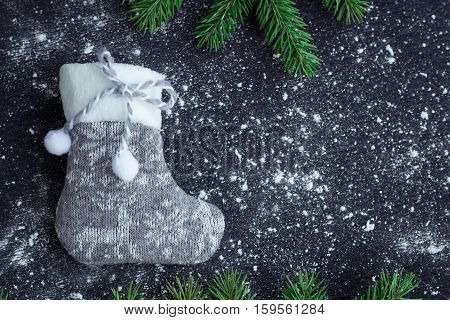 Grey Christmas Stocking On Snowbound Black Background With Fir Branches