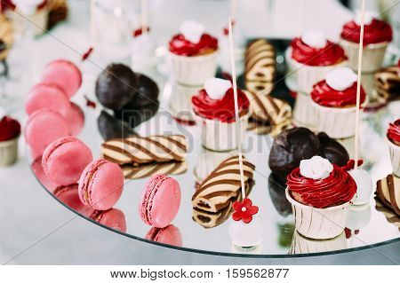 Dessert Sweet Tasty Cupcakes, Macarons And Cookies In Candy Bar On Table. Delicious Sweet Buffet. Wedding Holiday Decorations